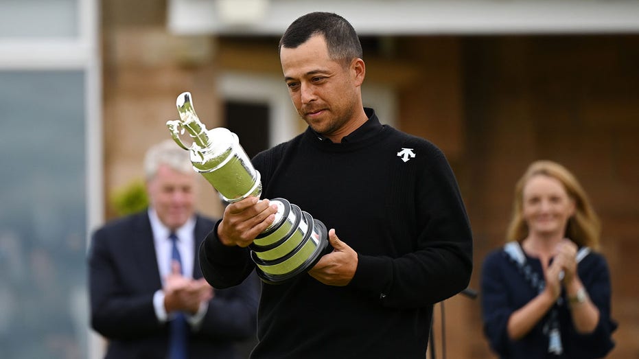 Xander Schauffele looks at a trophy