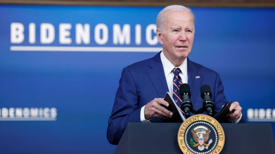 Biden berbicara dengan tanda tangan Bidenomics di latar belakang