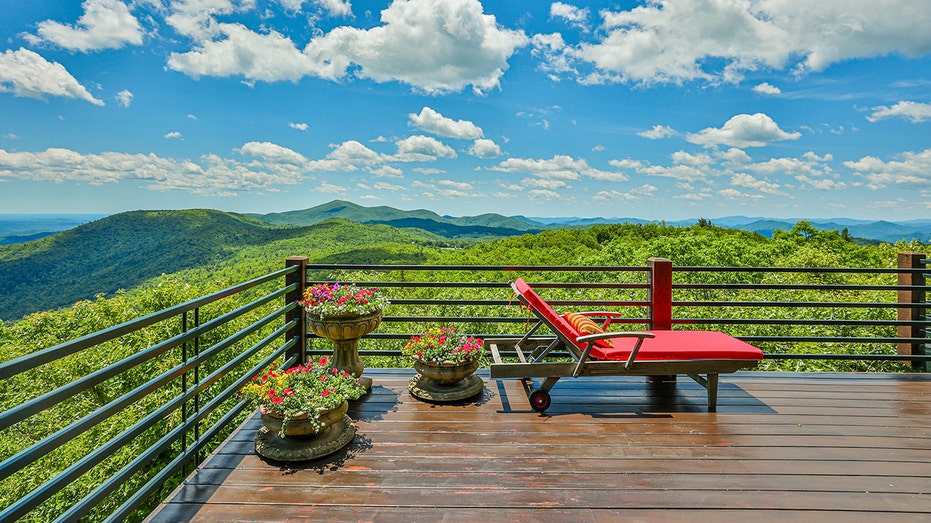 A red lounge chair overlooking a mountain view.