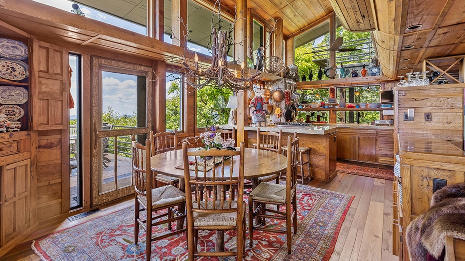 The living room features a round table and unique light fixture made of tree branches.