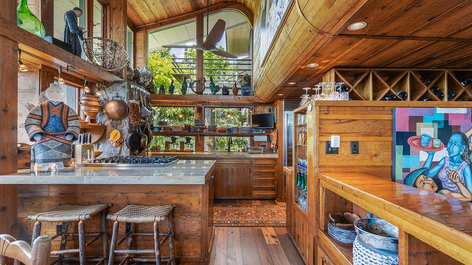 The kitchen features two ovens, a breakfast bar, a wine rack and big windows.