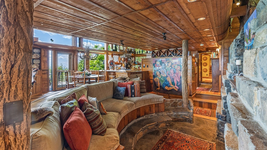 A sunken living room with a stone fireplace.