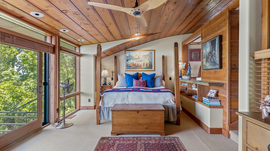 A bedroom with a wooden ceiling and white carpet