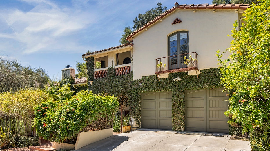 The two-car garage is covered with ivy on the outside.