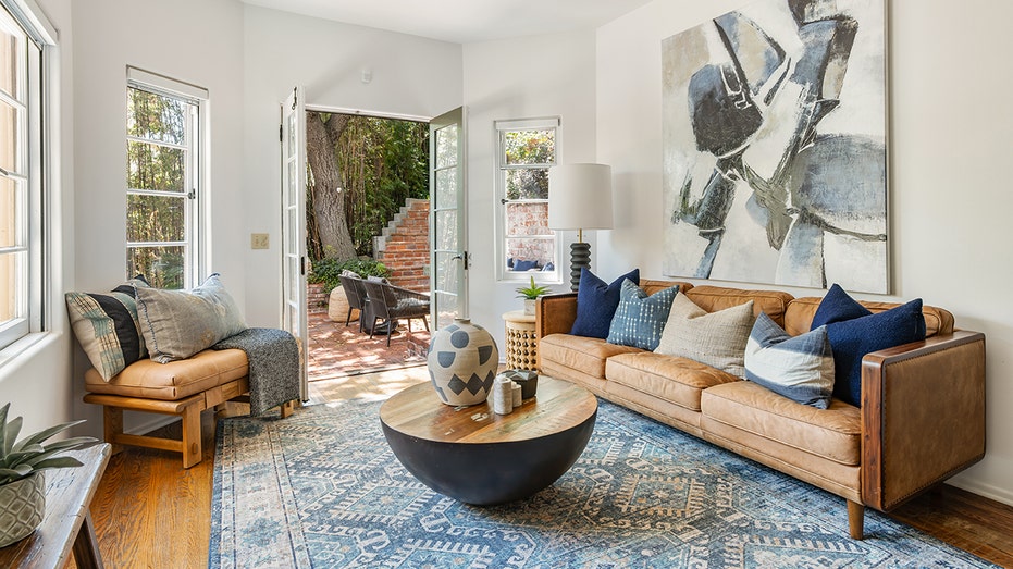 The sitting room connected to the kitchen features rustic hardwood floors and access to the backyard.