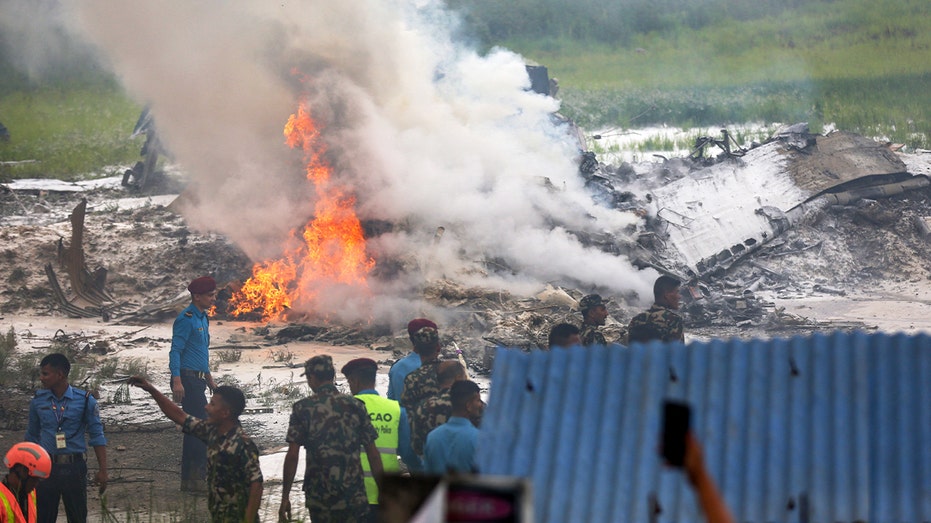 Fire erupts from a plane crash site in Nepal