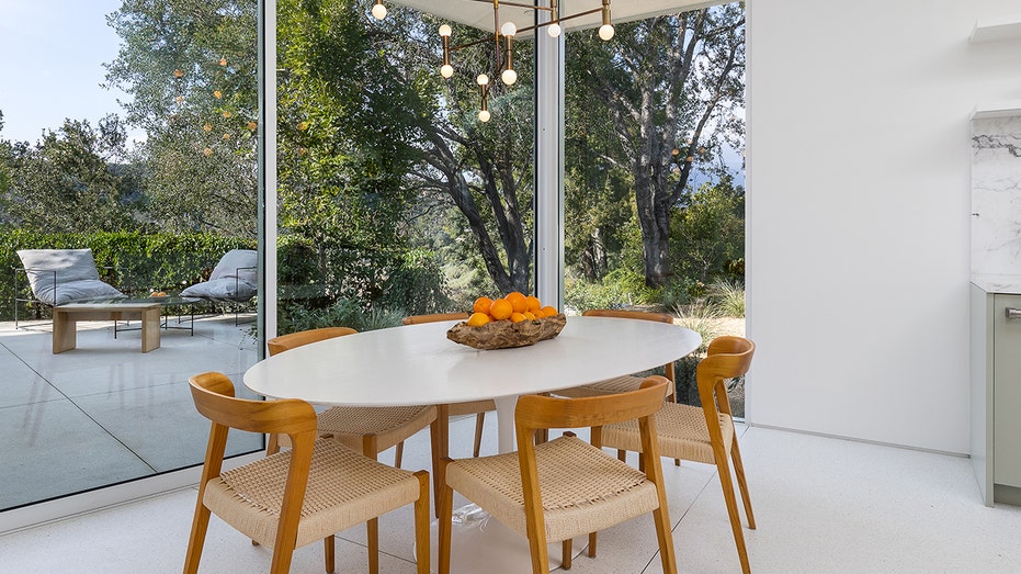 A table with wooden chairs in front of a big window