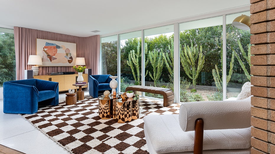 The living room features white tile floors and floor to ceiling windows.