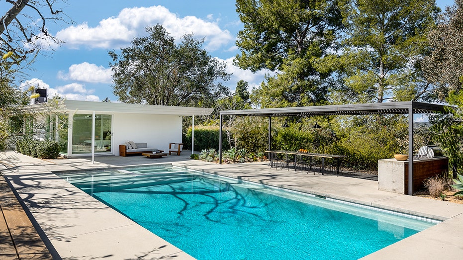 The backyard boasts a swimming pool and an outdoor dining area.