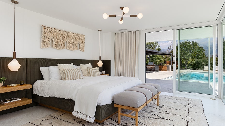 The primary bedroom features a built-in headboard with shelving, and direct access to the backyard.