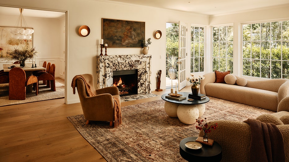 The living room features a wood burning fireplace, big windows and wooden floors.