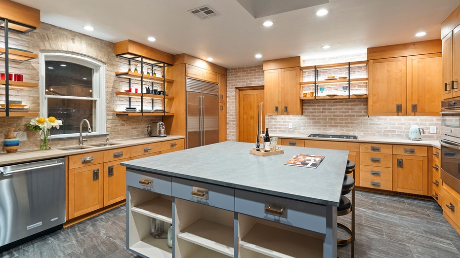A kitchen with brown cabinets and an island