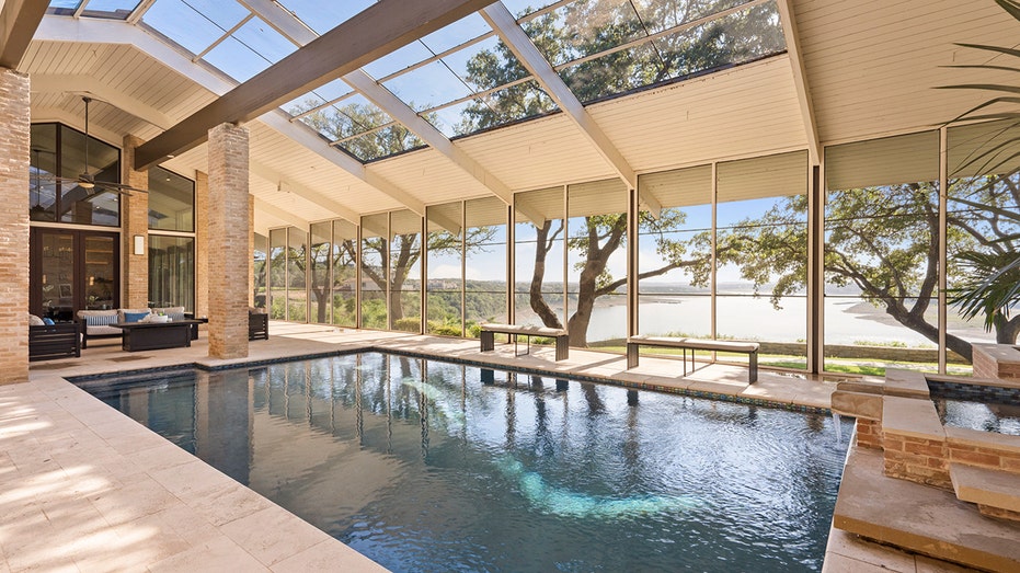 The great room leads to an indoor swimming pool with a lounge area and waterfall.