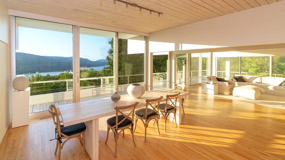 The dining room has plenty of natural light, brought in by the surrounding floor to ceiling windows.