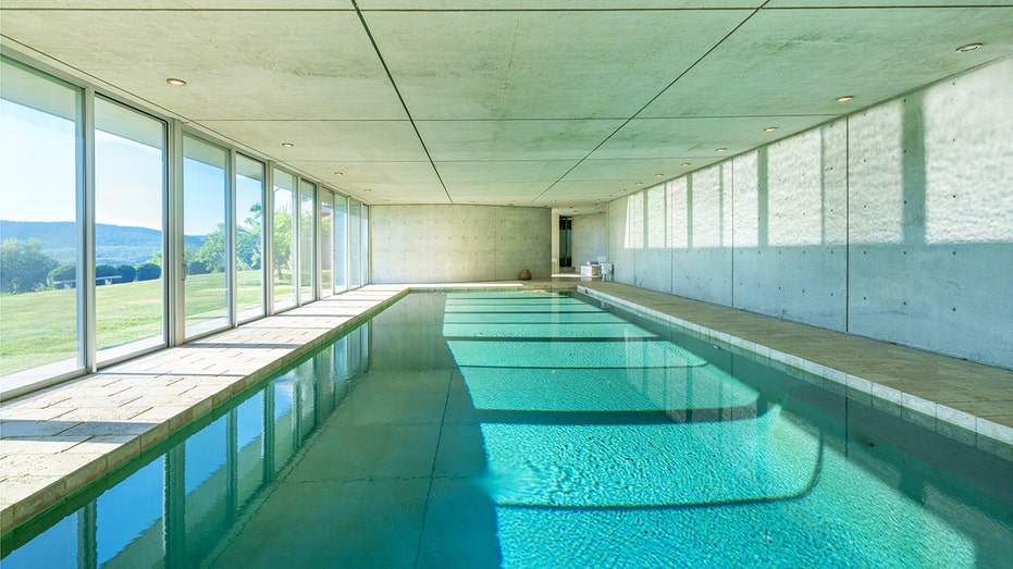 An indoor swimming pool with a window wall on one side.