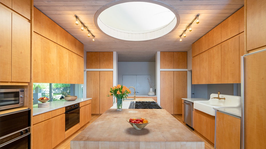 The kitchen features a large island and a circular skylight, which brings in plenty of natural light.