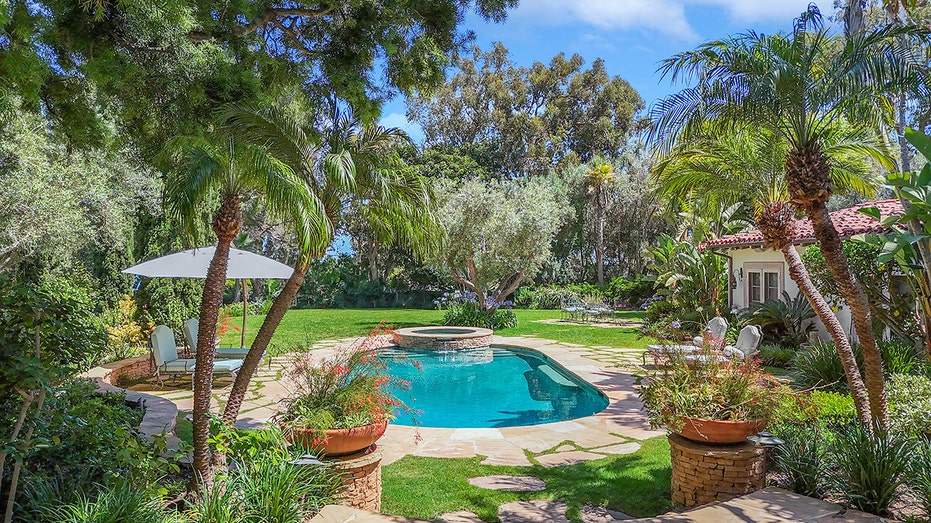 The outside features a large pool, surrounded by lush grass.