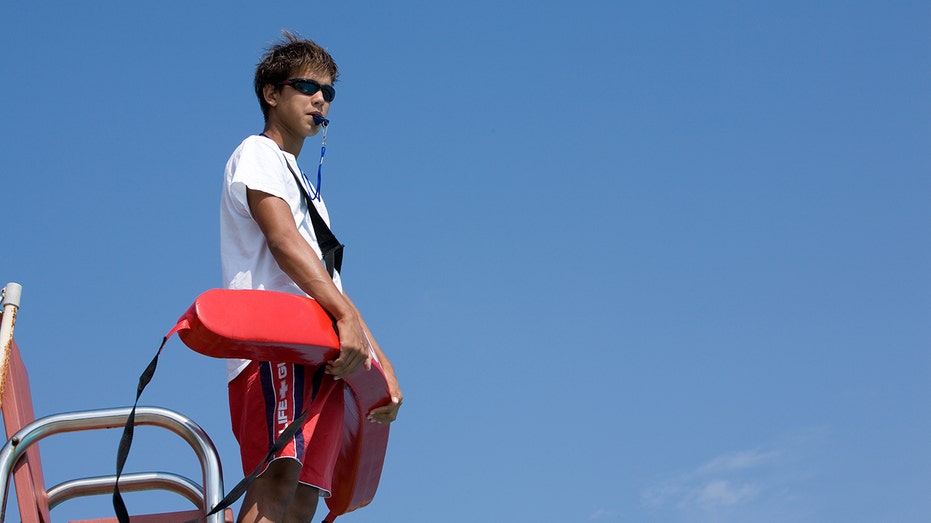 Young lifeguard working at pool 