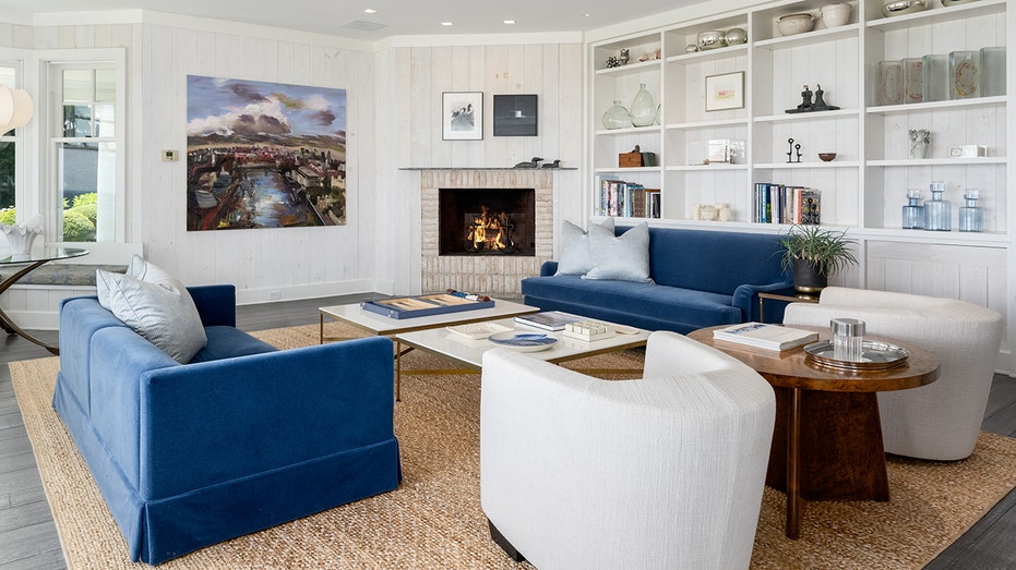 The living room features floor to ceiling windows, built-in shelves and a fireplace.