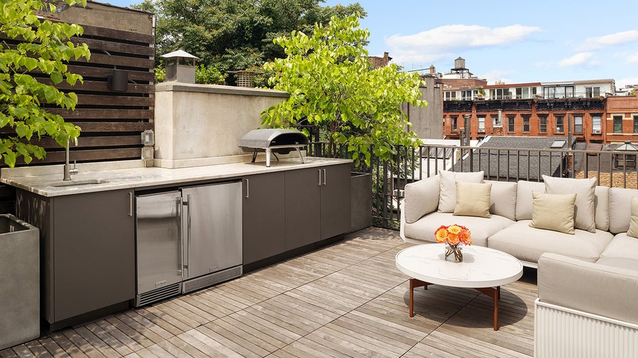 Outdoor space with a grill and couch and table