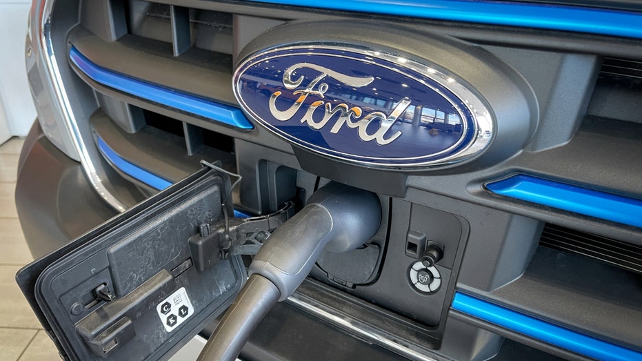 The logo of the Ford Motor Company is displayed on the front grille of an electric Ford Transit being charged in a dealership on March 5, 2023 in Bristol, England.