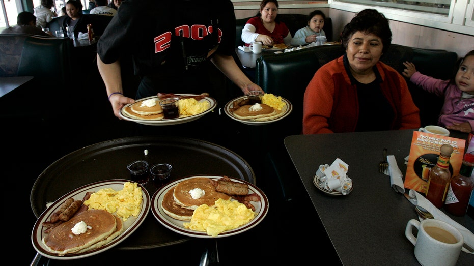 Waitress serving "Grand Slam" breakfasts to patrons.