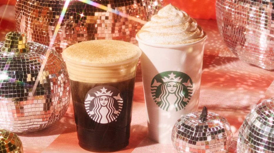 An iced and hot pumpkin spiced latte from Starbucks surrounded by pumpkin-shaped disco balls.