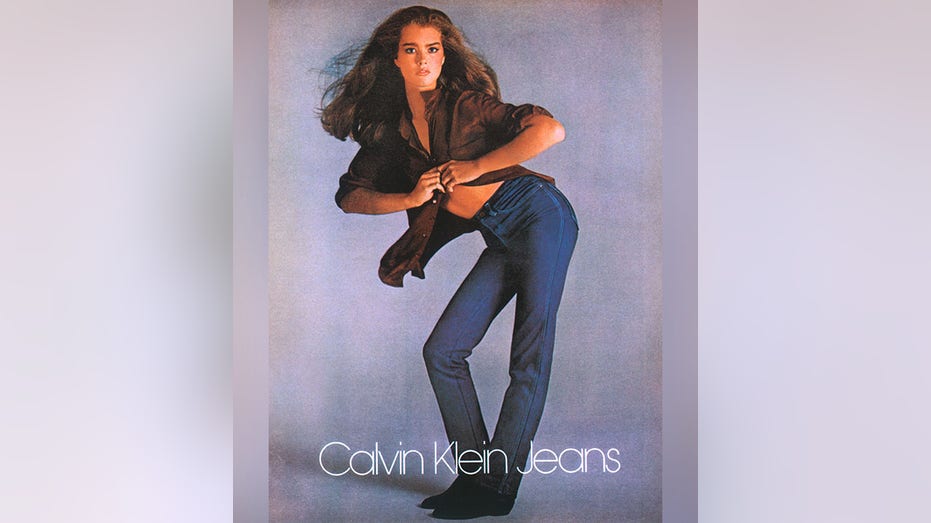 Brooke Shields poses in her Calvin Klein Jeans and a semi open brown blouse for a 1980 commerical