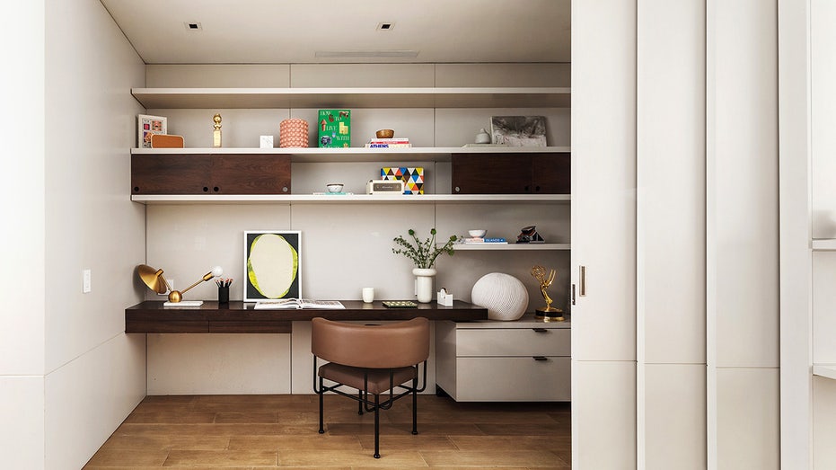 A long desk with a brown leather chair can be hidden with folding doors