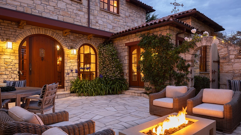 The font of a home features a courtyard with a firepit and seating.