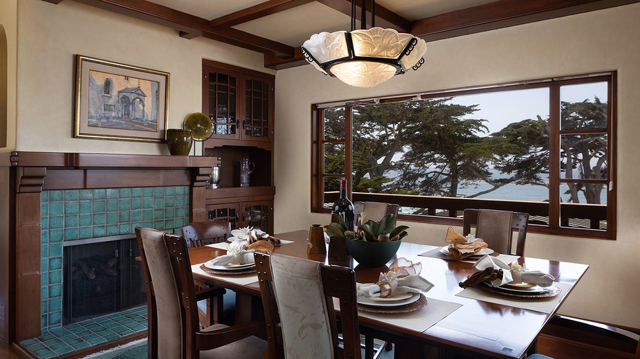 The dining room features a vaulted ceiling with exposed wood, as well as a gas fireplace and big windows.