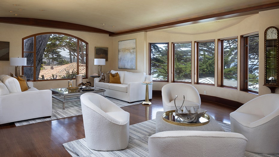 The living room features dark wood floors, a gas fireplace and large windows.