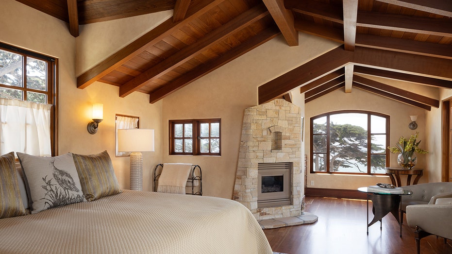 The primary bedroom features a gas fireplace and exposed wooden ceilings.