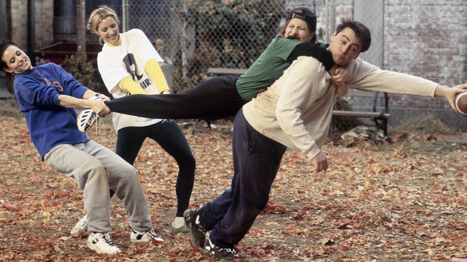 The cast of Friends playing football.