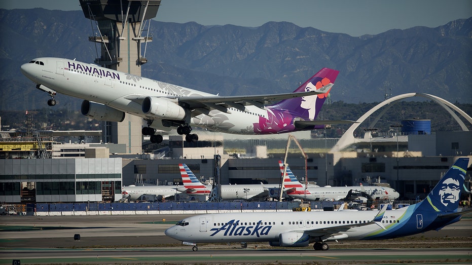 Hawaiian, Alaska airlines planes next to each other at LAX