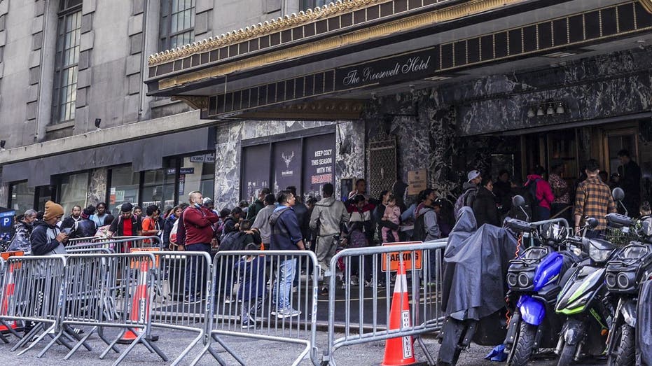 migrants lined up outside New York's Roosevelt Hotel