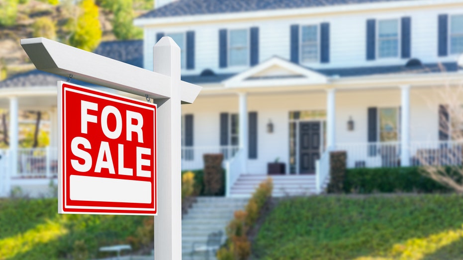 House with for sale sign in front