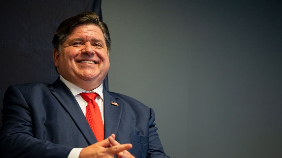 J.B. Pritzker smiling at cameras