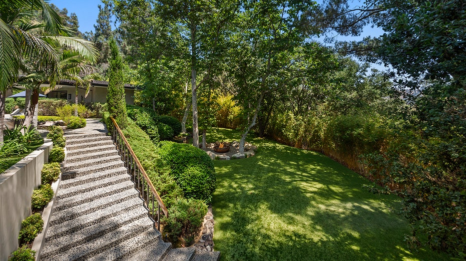 The grass field features a fire pit, perfect for entertaining.