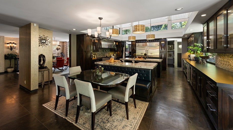 Renner's kitchen features all black cabinets and a breakfast nook.