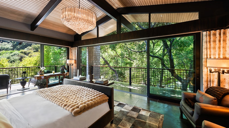 The master bedroom features a private wraparound balcony and floor-to-ceiling windows.