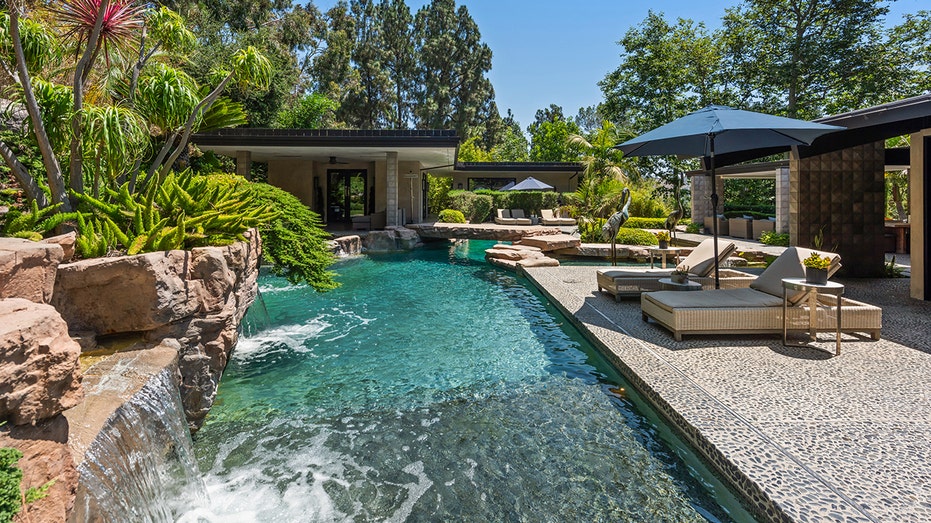 The backyard features a swimming pool with two waterfalls.