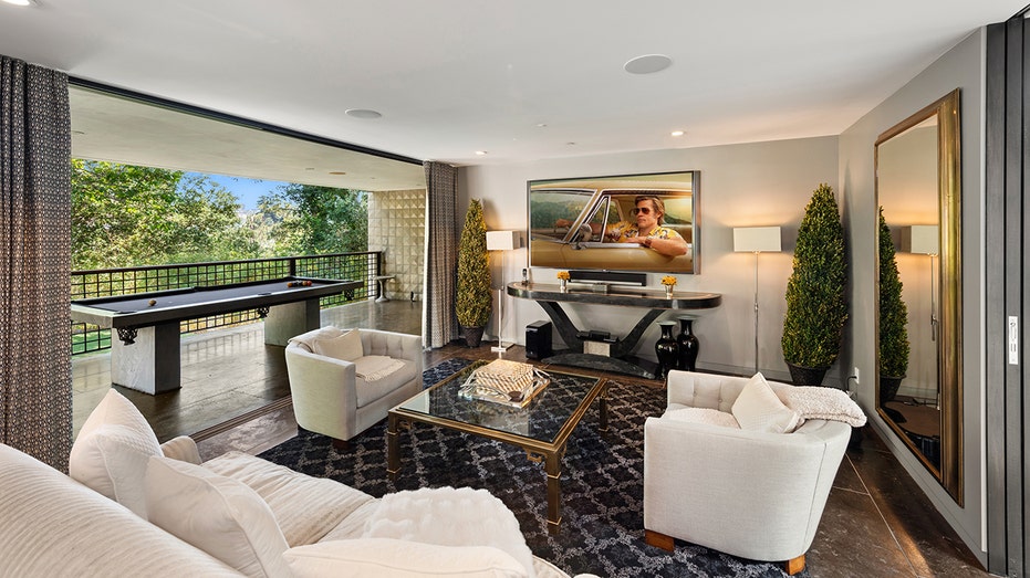 The house has another living room with a pool table and a TV.