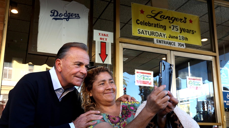 langers deli man and woman pose for photo