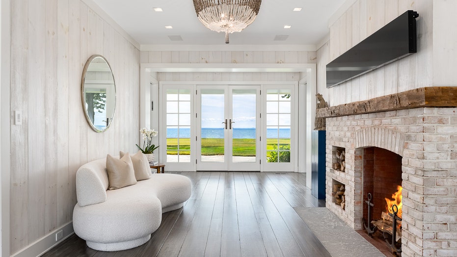 The home's entry features a stone fireplace and stunning views of the ocean.