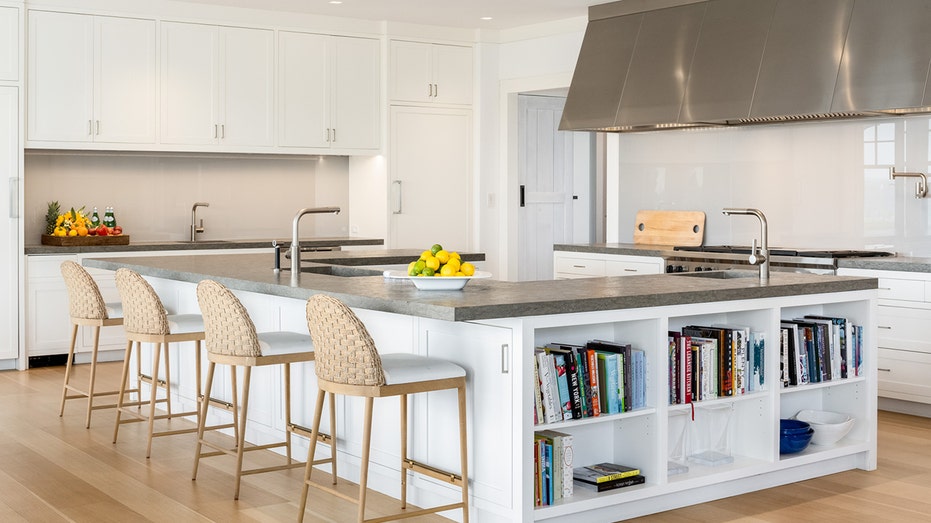 The kitchen has a big center island with built-in bookshelves.