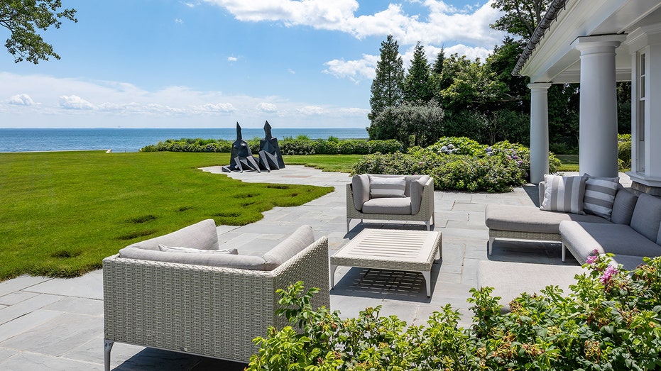 The home's backyard features a patio overlooking the ocean.