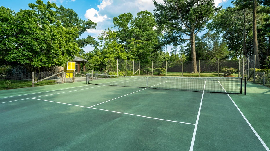 The grounds feature a full-sized clay tennis court.