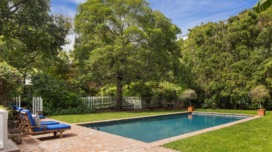 Pool surrounded by brick walkway and grass