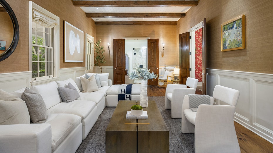 White coach and chairs centered around a dark wood coffee table